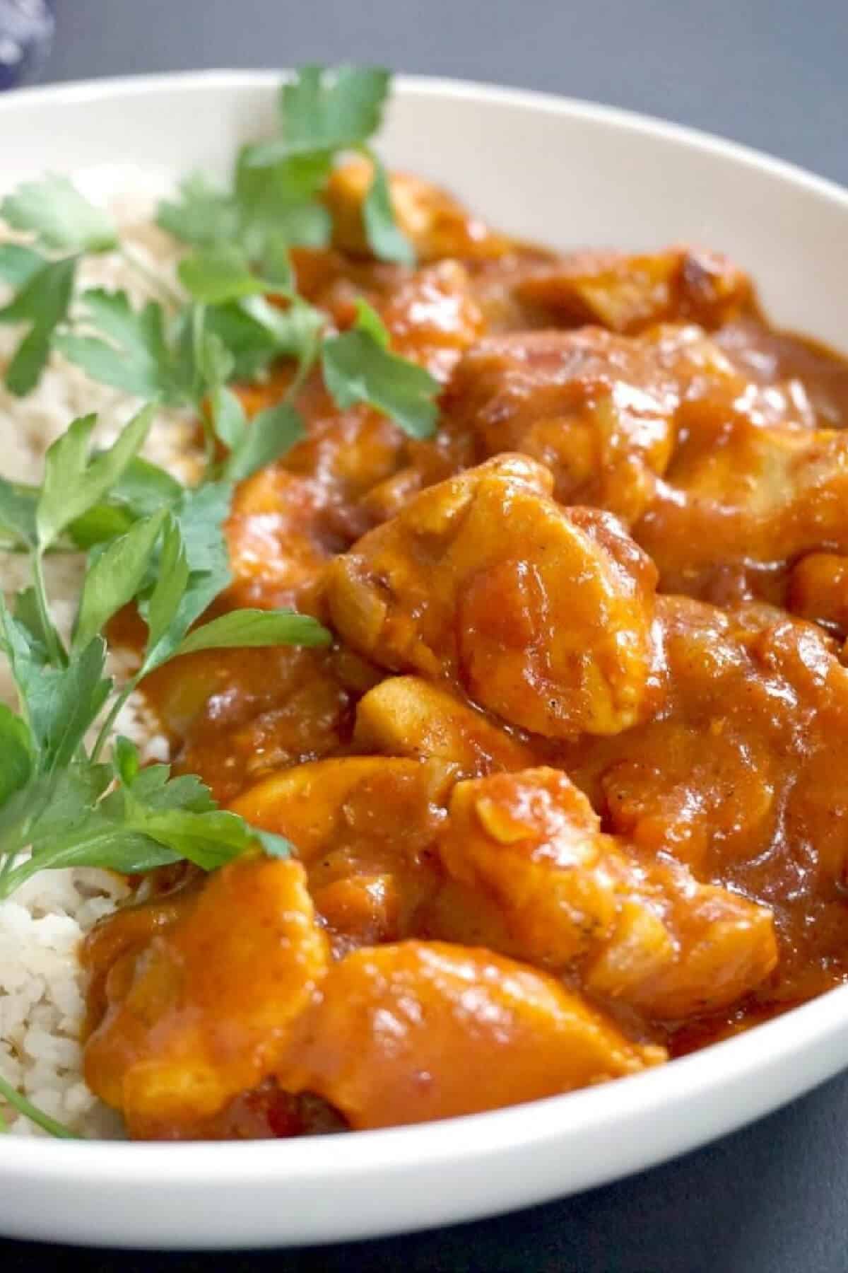 A white bowl with chicken curry.