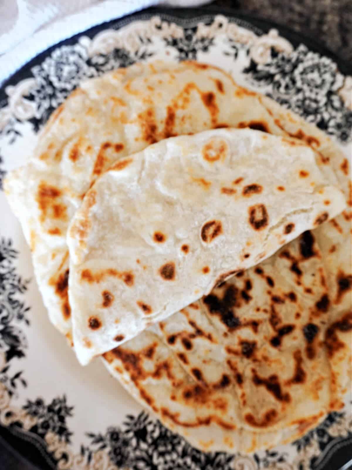 Overhead shot of a folder flat bread on top of other flat breads.