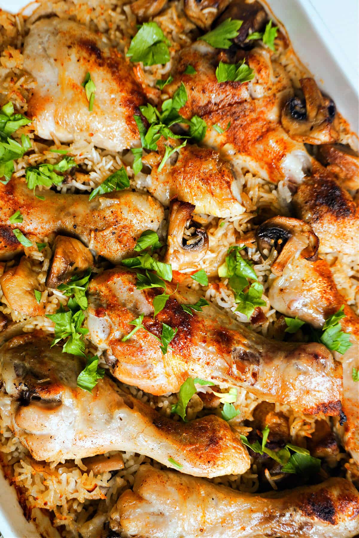 Close-up shoot of a dish with chicken drumsticks and rice.