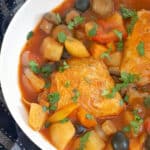 A white bowl with chicken cacciatore