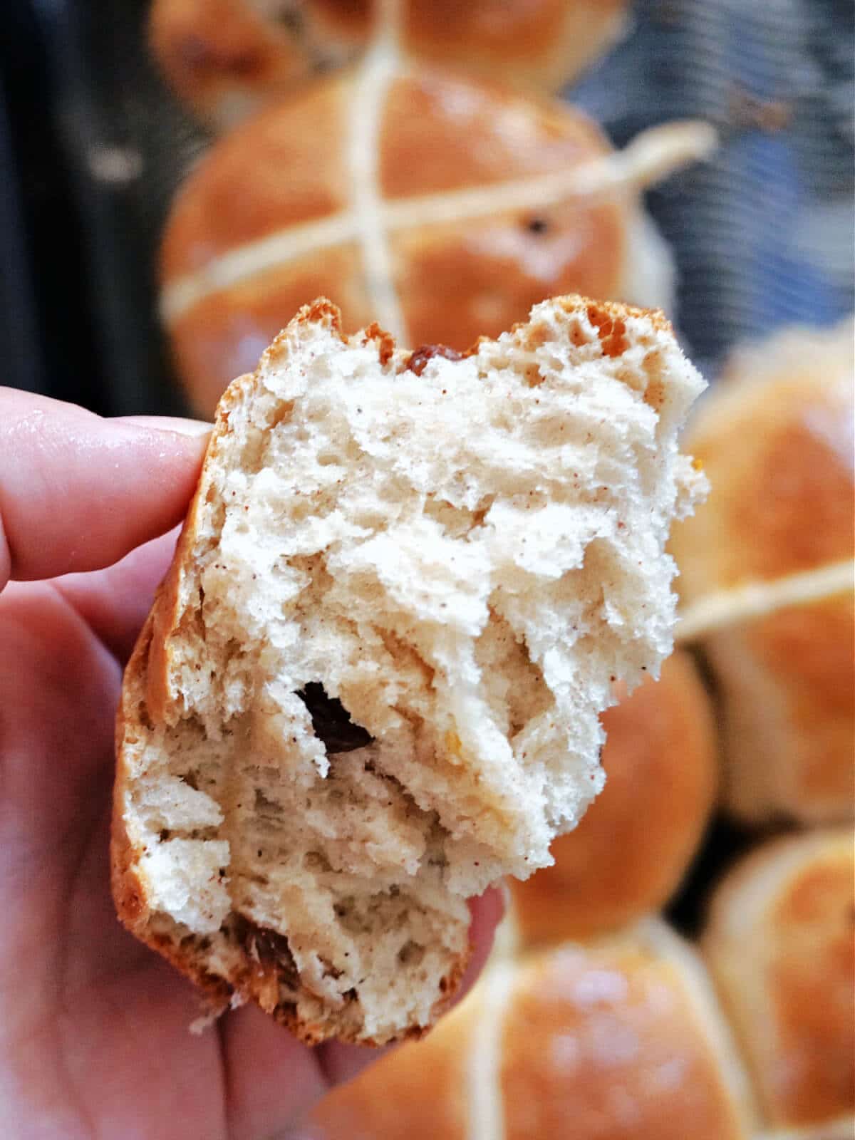 A piece of torn open hot cross bun to show how fluffy it is