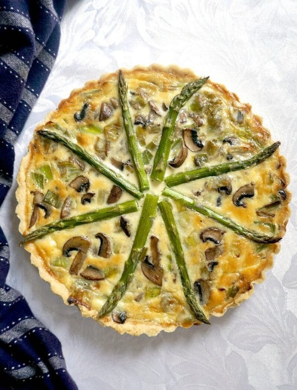 Overhead shoot of a quiche with asparagus, mushrooms and leeks