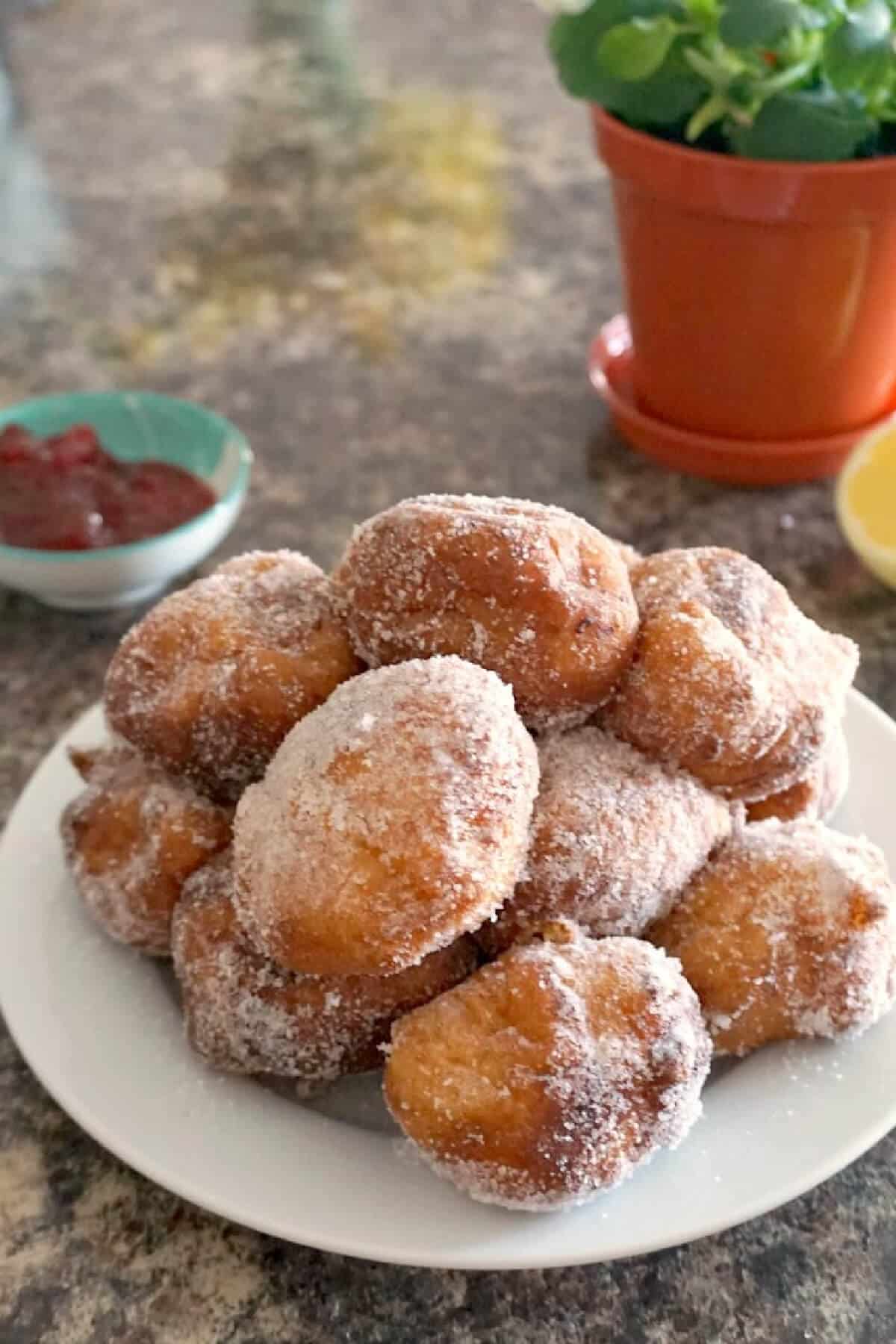 A white plate with beignets.
