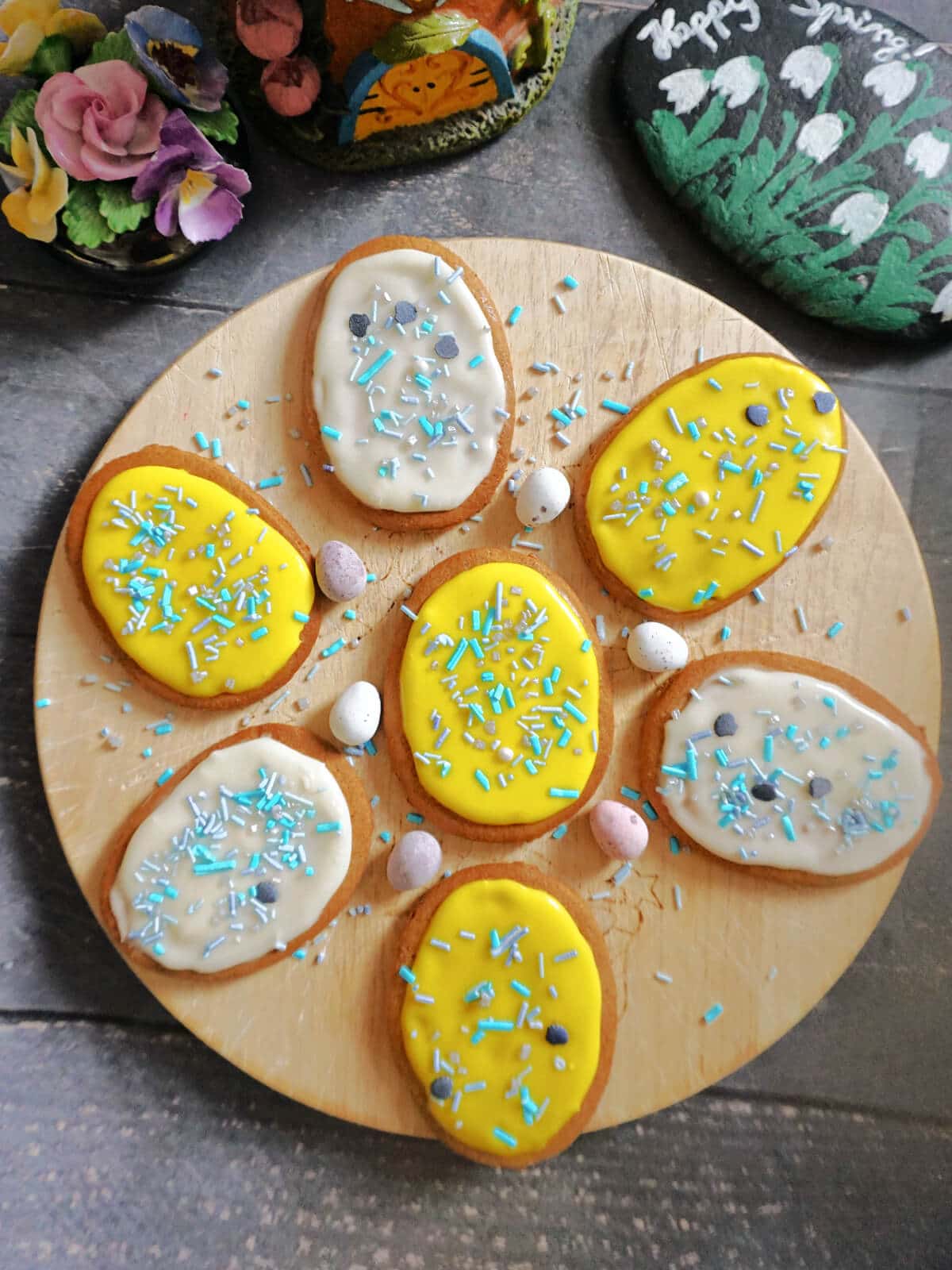 Overhead shot of a round wooden board with 7 gingerbread easter eggs.