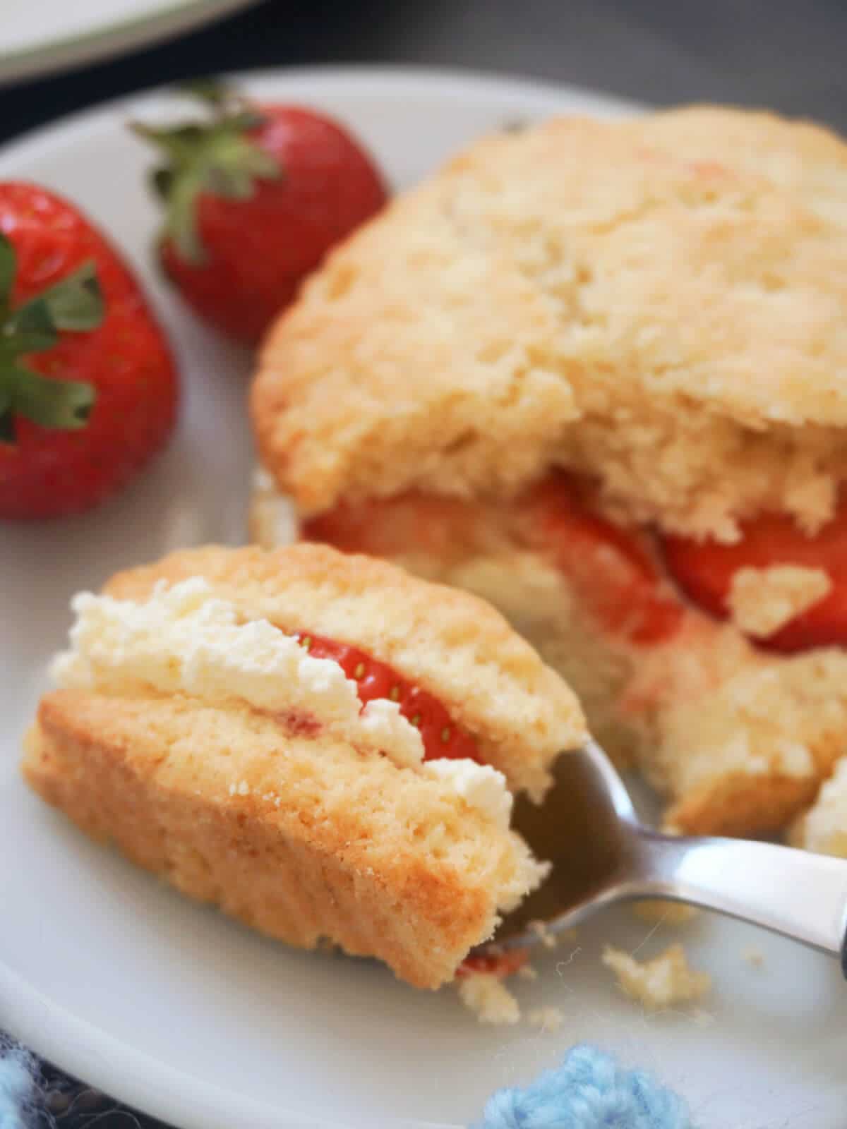 A teaspoon of shortcake with strawberry and cream.