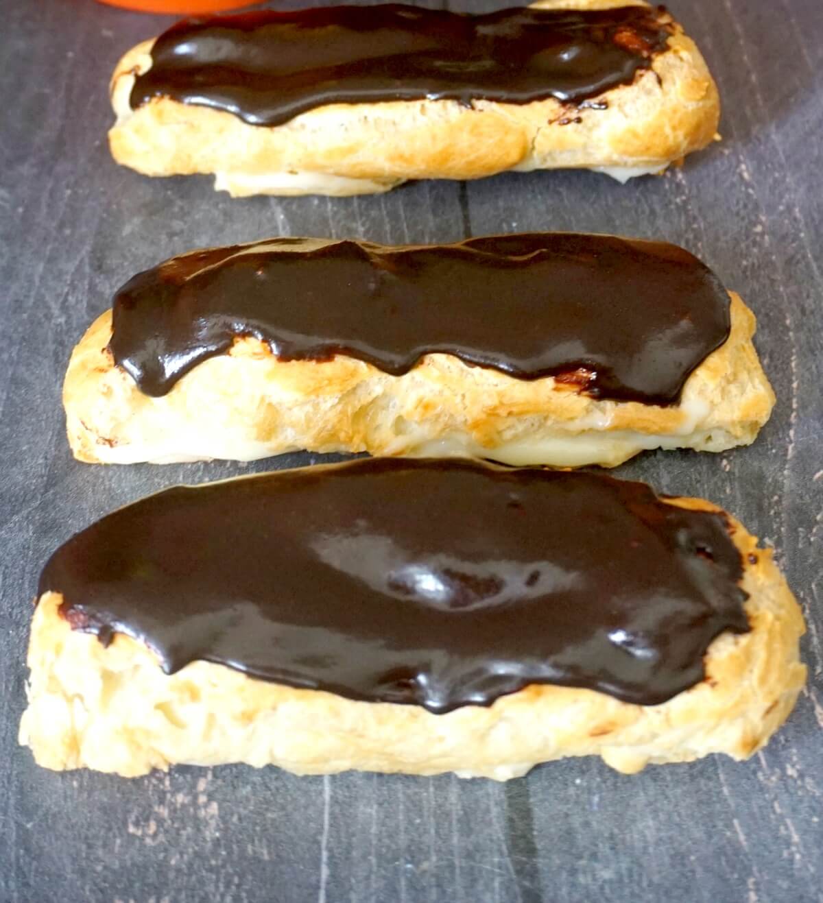 3 eclairs on a table top.