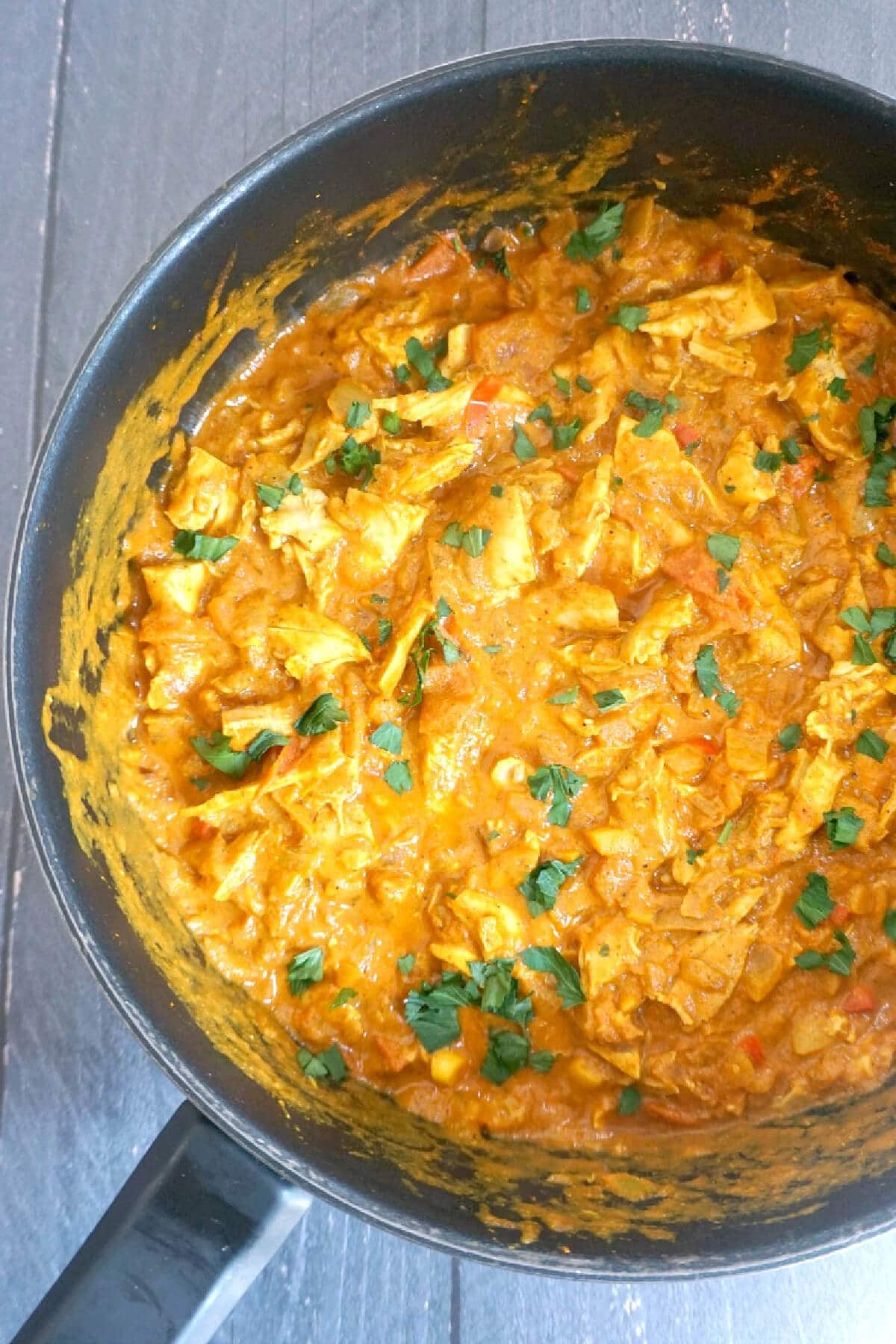 Overhead shoot of a pot with chicken curry.