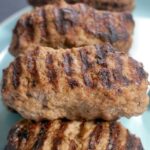 Close-up shoot of Romanian mici on a blue plate