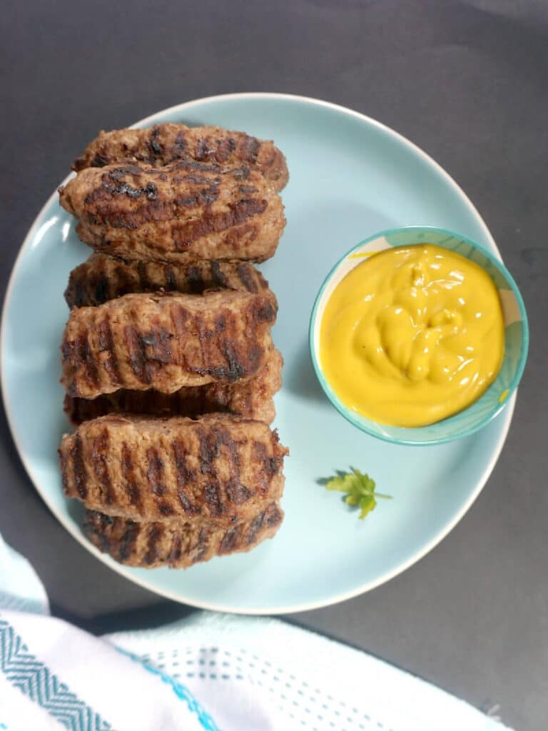 Overhead shoot of a blue plate with mici and a small ramekin with mustard