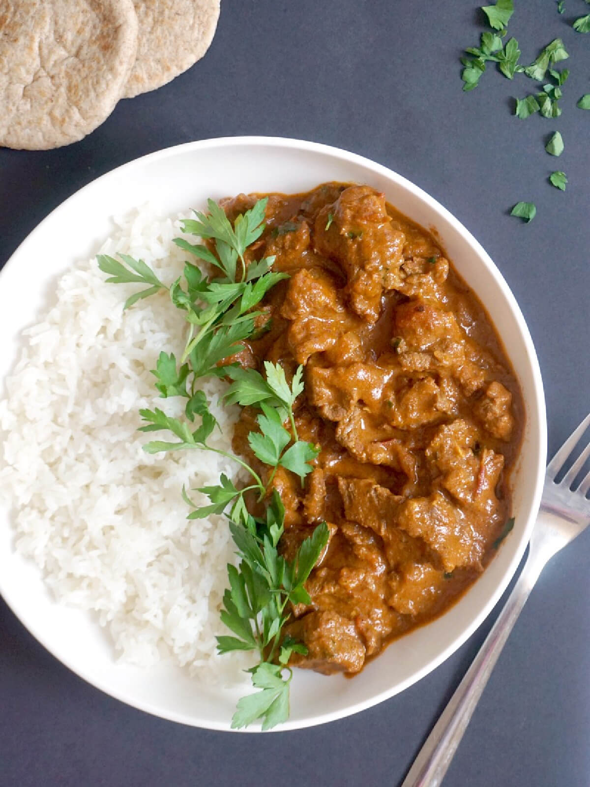 Overhead shoot of a white bowl with rice and beef curry.