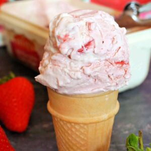 A cone with a scoop of strawberry ice cream