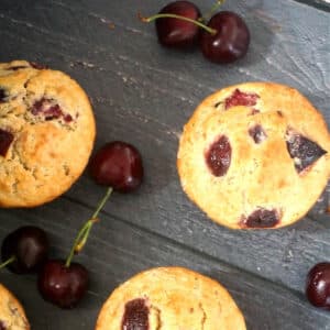 Overhead shoot of 3 cherry muffins with cherries around them