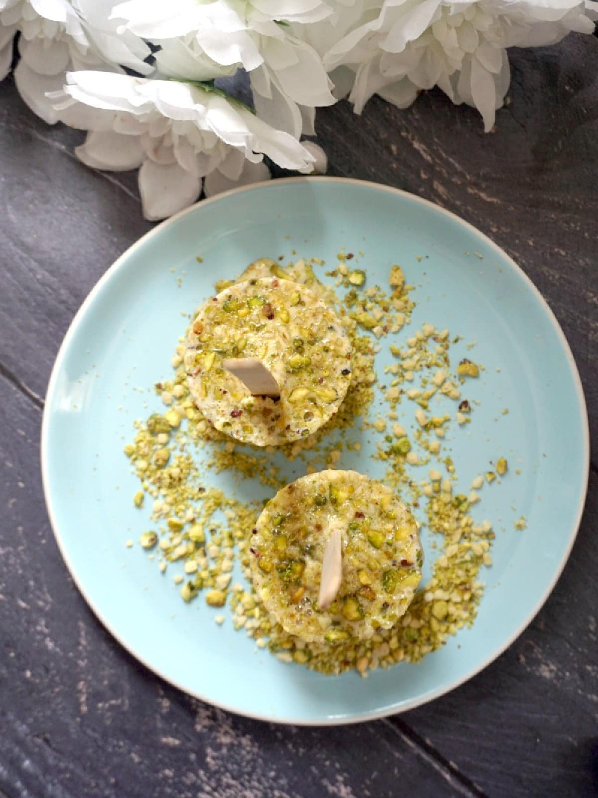 Overhead shoot of a light blue plate with 2 kulfi recipes.