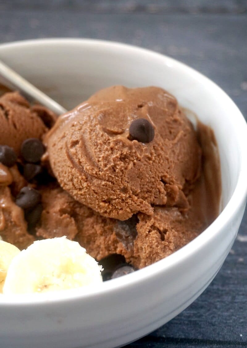 A white bowl with scoops of banana and chocolate ice cream and a few slices of banana