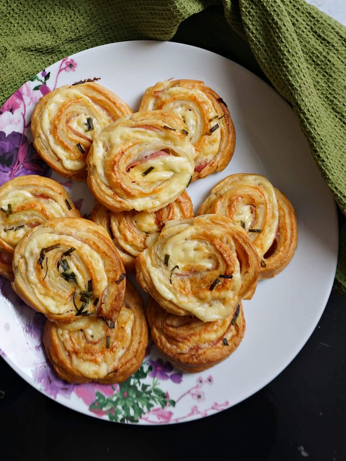 A plate with a pile of puff pastry pinwheels.