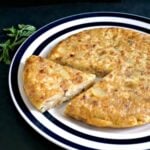A plate with a Spanish tortilla and a slice cut out of it