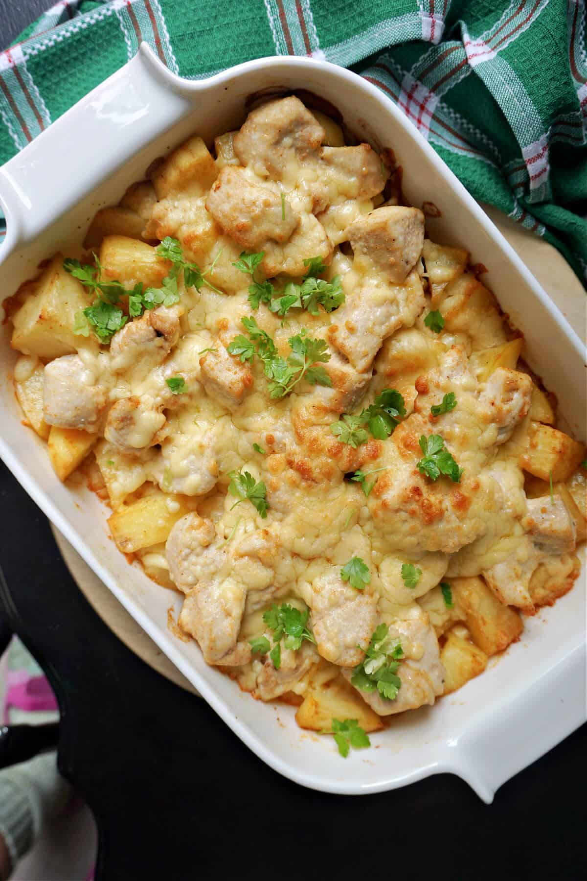 Overhead shoot of a dish with a cheesy chicken and potato bake.