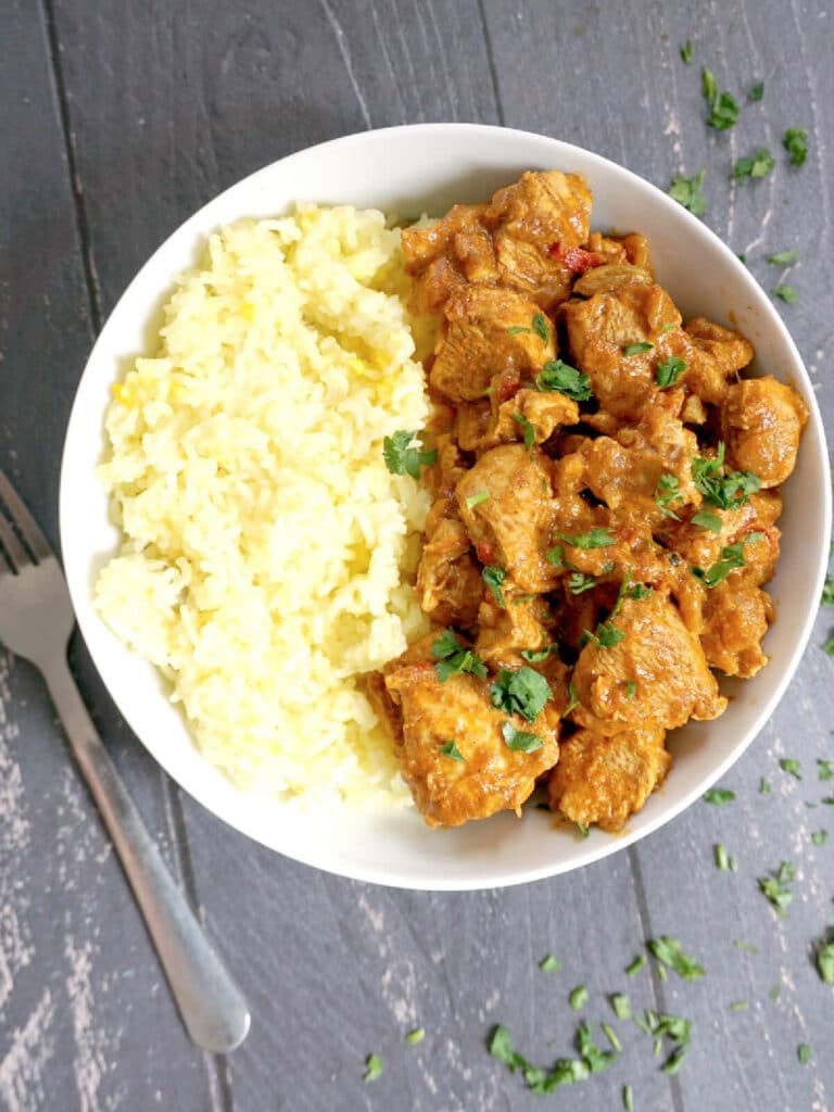 Overhead shoot of a white bowl with rice and chicken curry