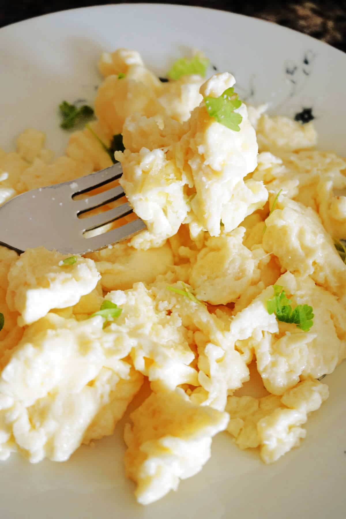 Close-up shot of scrambled eggs and a fork.