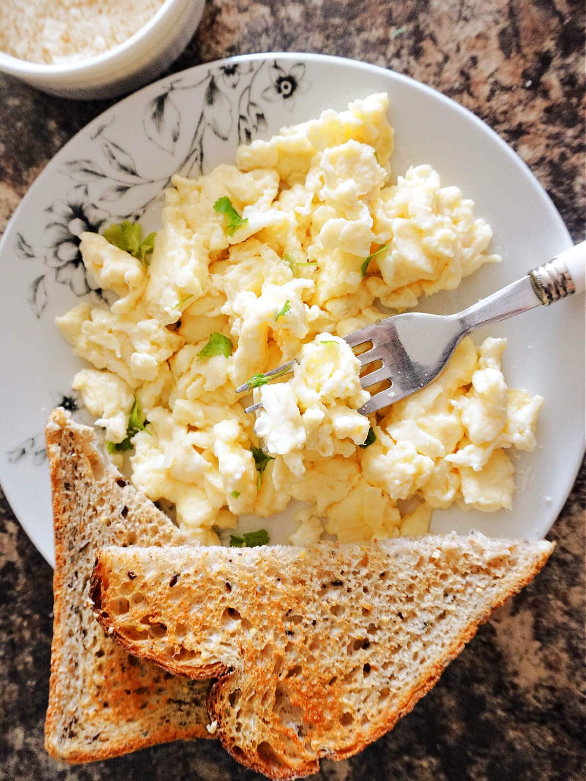 Overhead shot of a plate with scrambled eggs and 2 slices of toast.