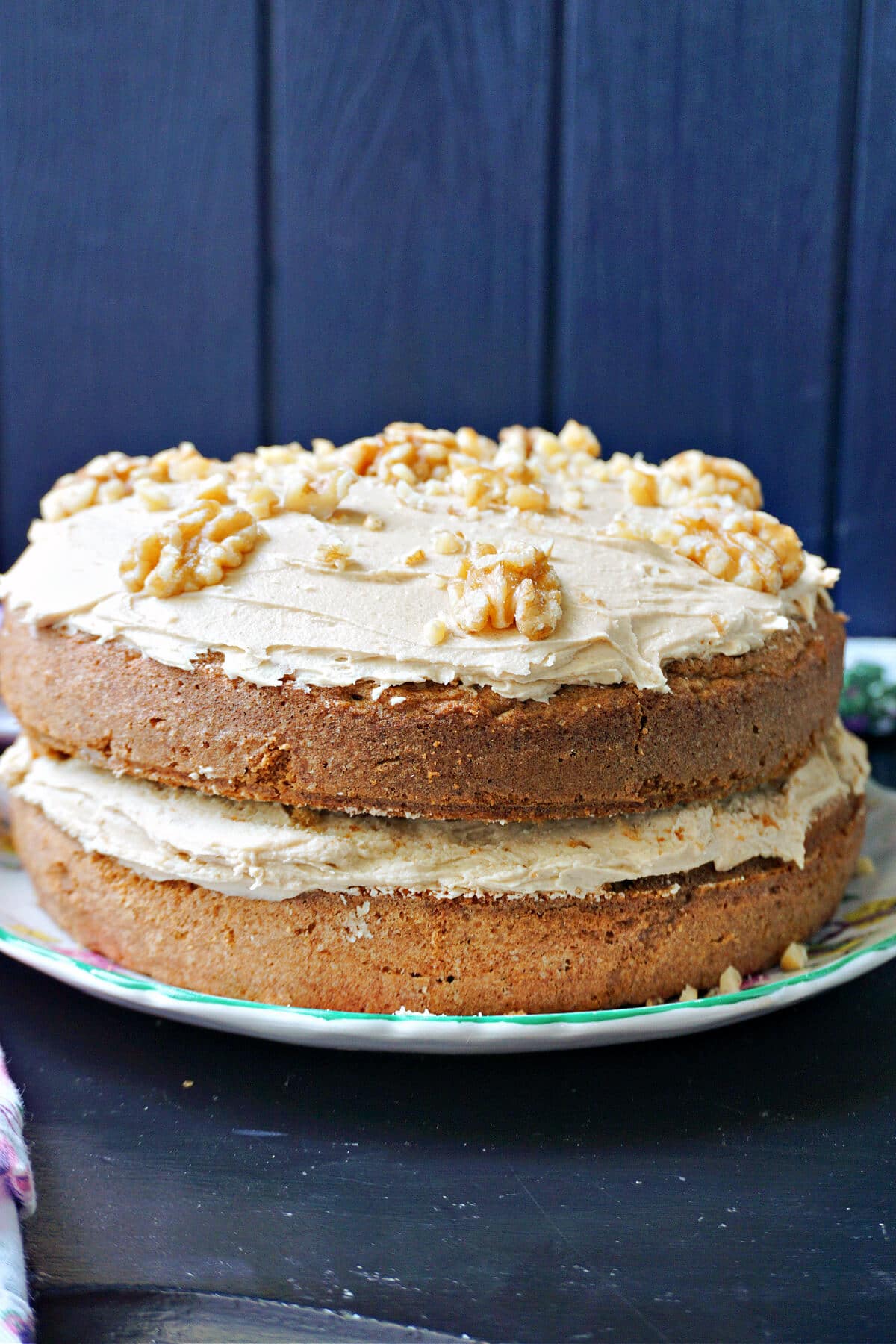 A coffee and walnut cake on a cake stand.