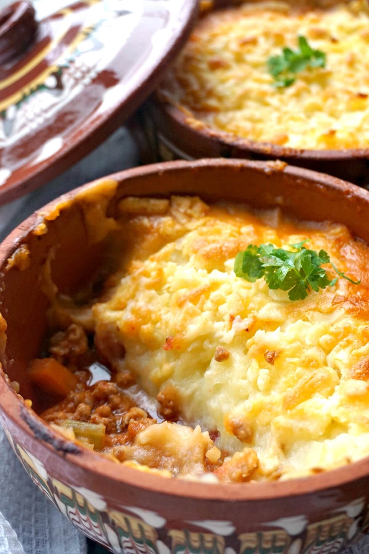 A pot with turkey cottage pie and another pot in the background.