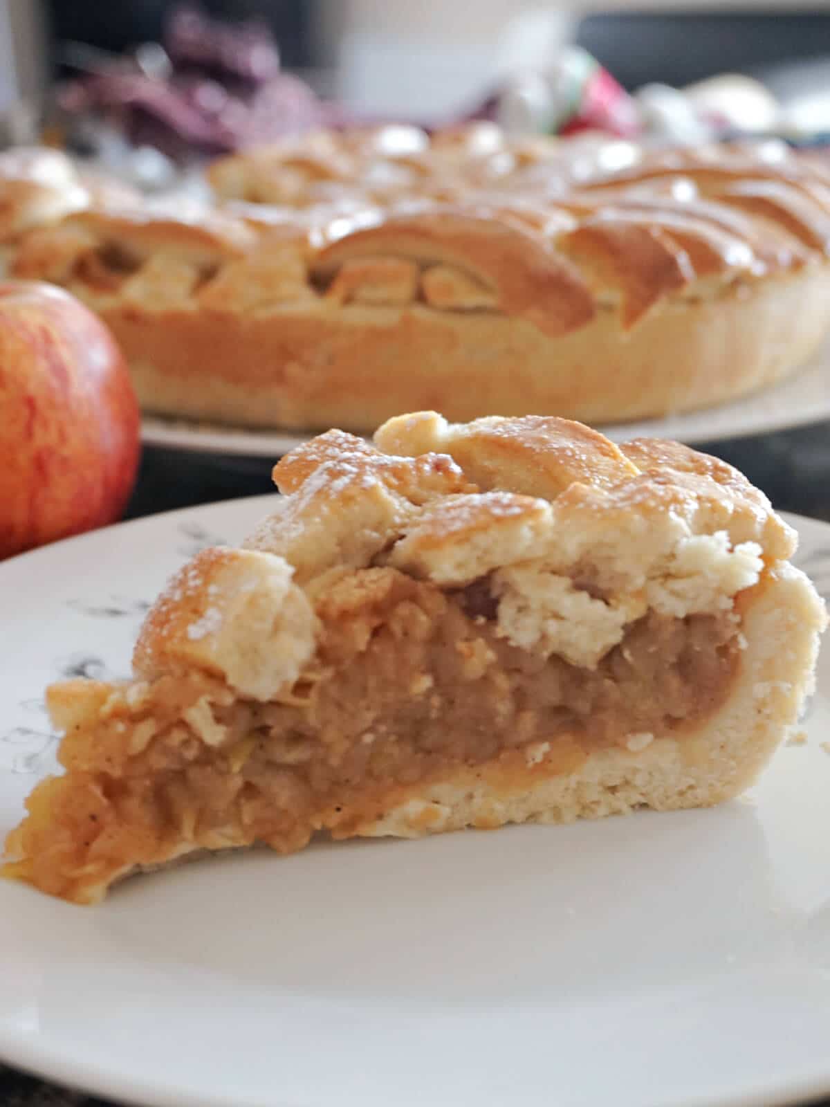 A slice of apple pie on a white plate.