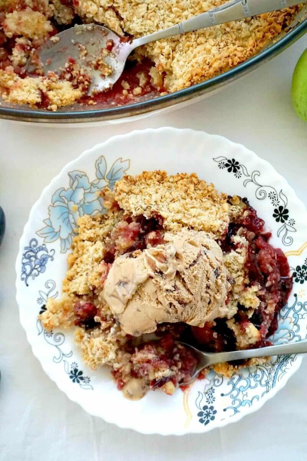 Overhead shoot of a plate with apple and plum crumble.
