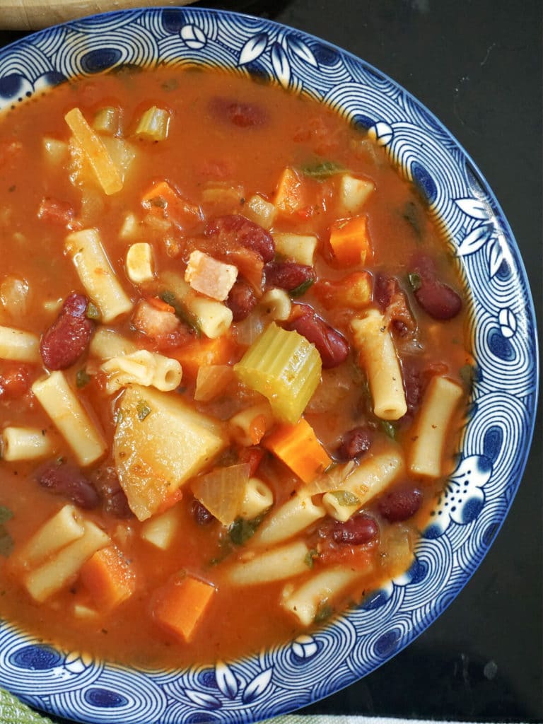 Close-up shoot of a blue bowl of minestrone soup