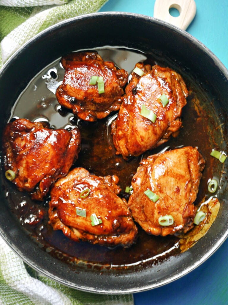 A pan with 5 chicken thighs in an adobo sauce