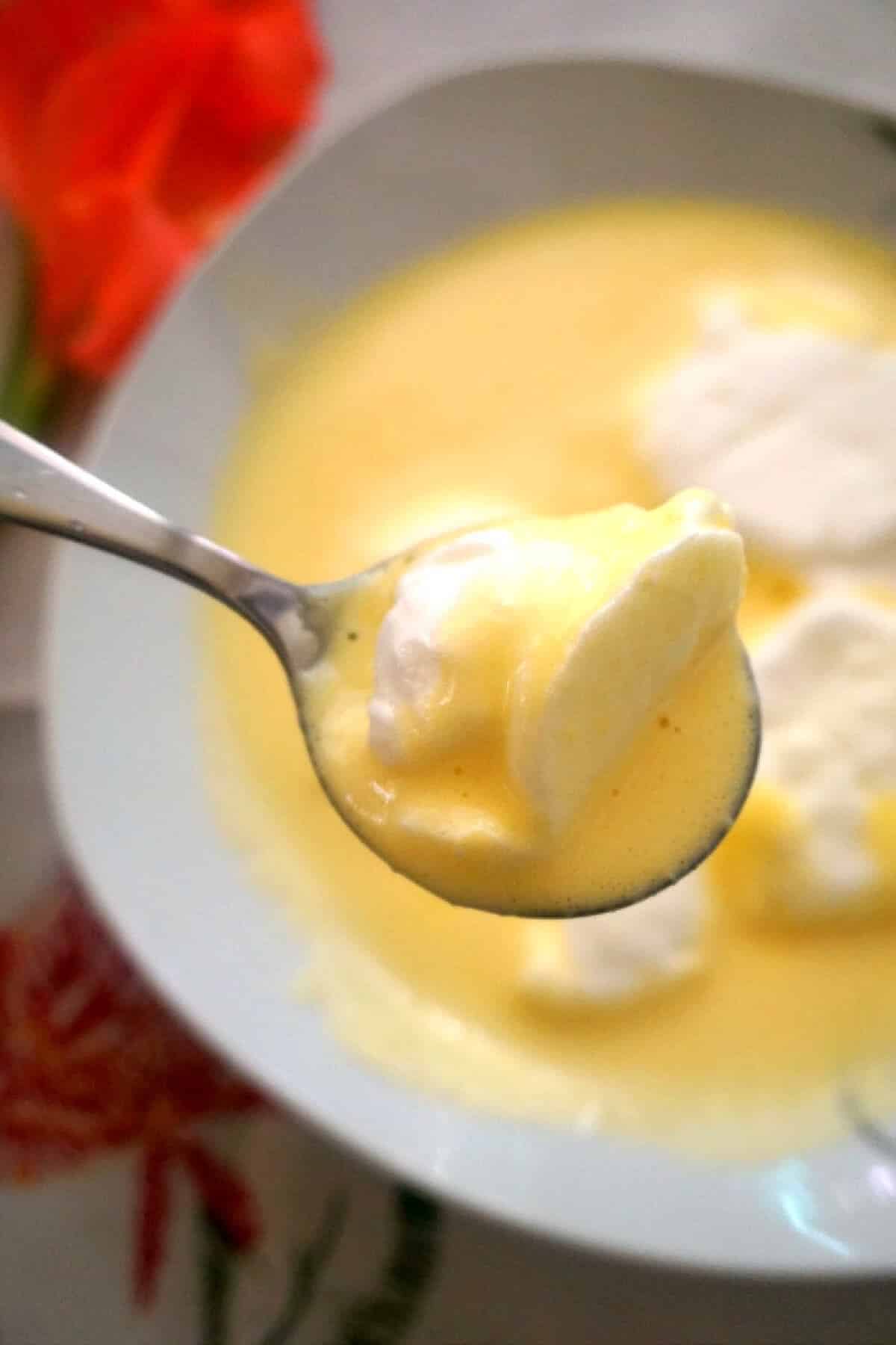 A spoonful of custard with egg white balls.