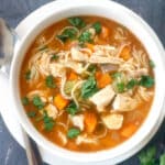 Overhead shoot of a white bowl with chicken noodle soup