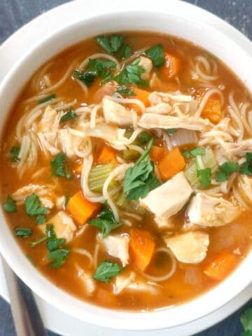 Overhead shoot of a white bowl with chicken noodle soup