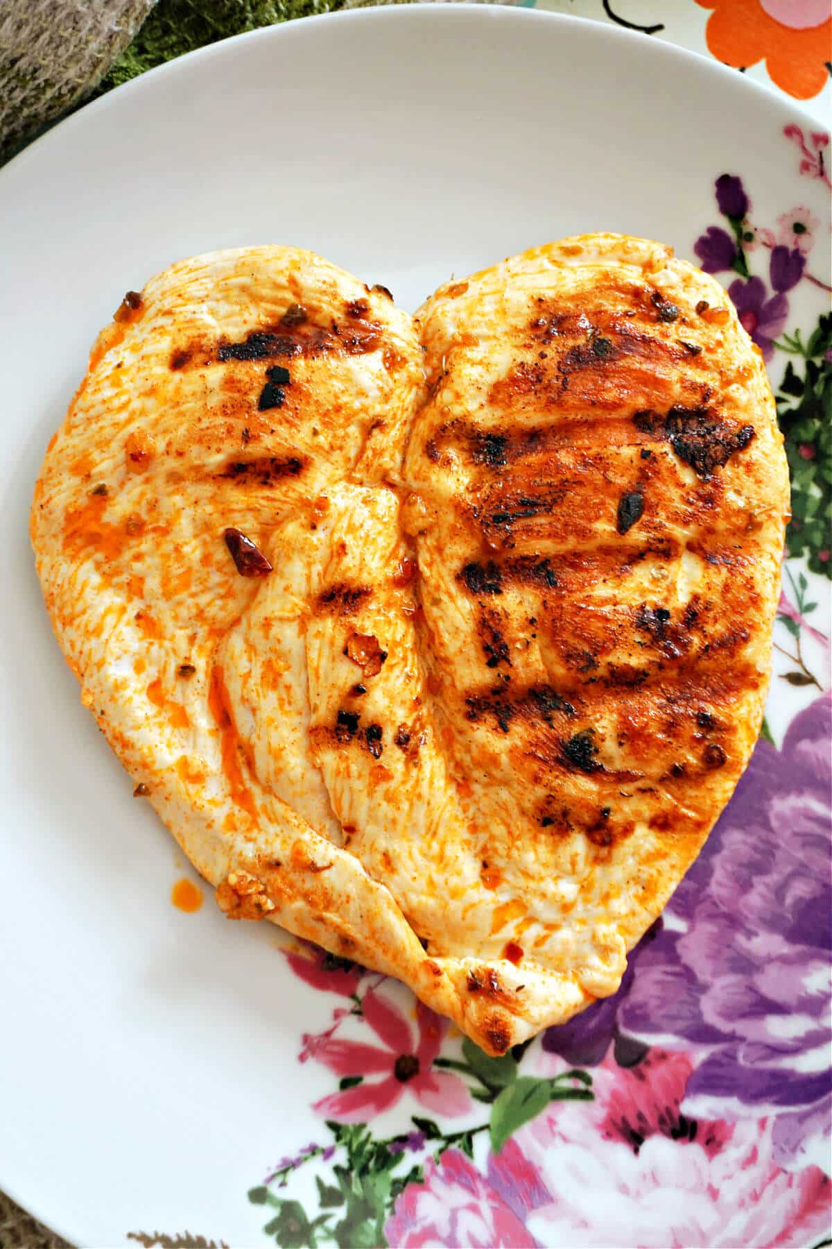 A butterflied chicken breast on a plate.