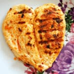 A butterflied chicken breast on a plate.