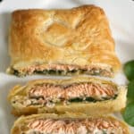 A salmon wellington with 2 slices cut out of it