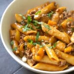 A white bowl with ground beef pasta