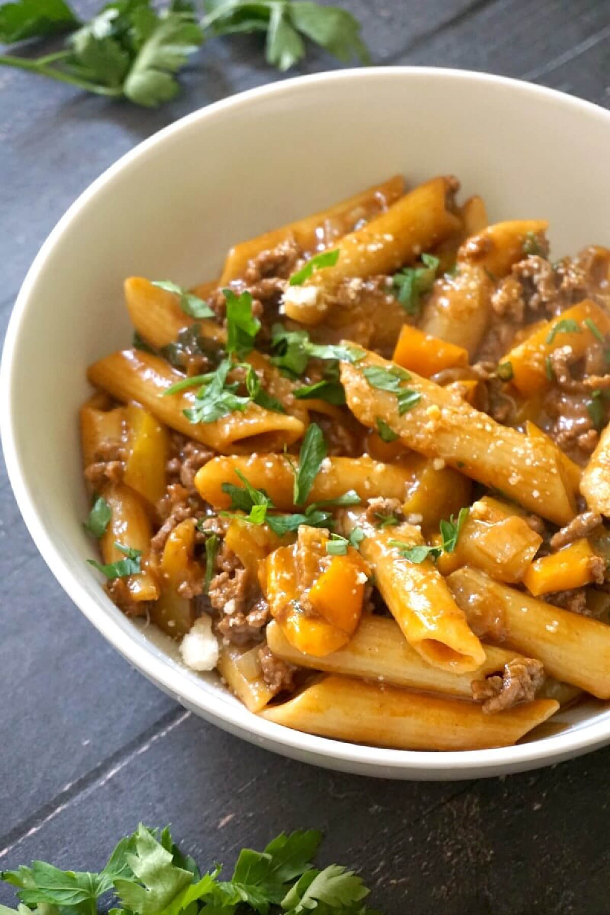 A white bowl with ground beef pasta.