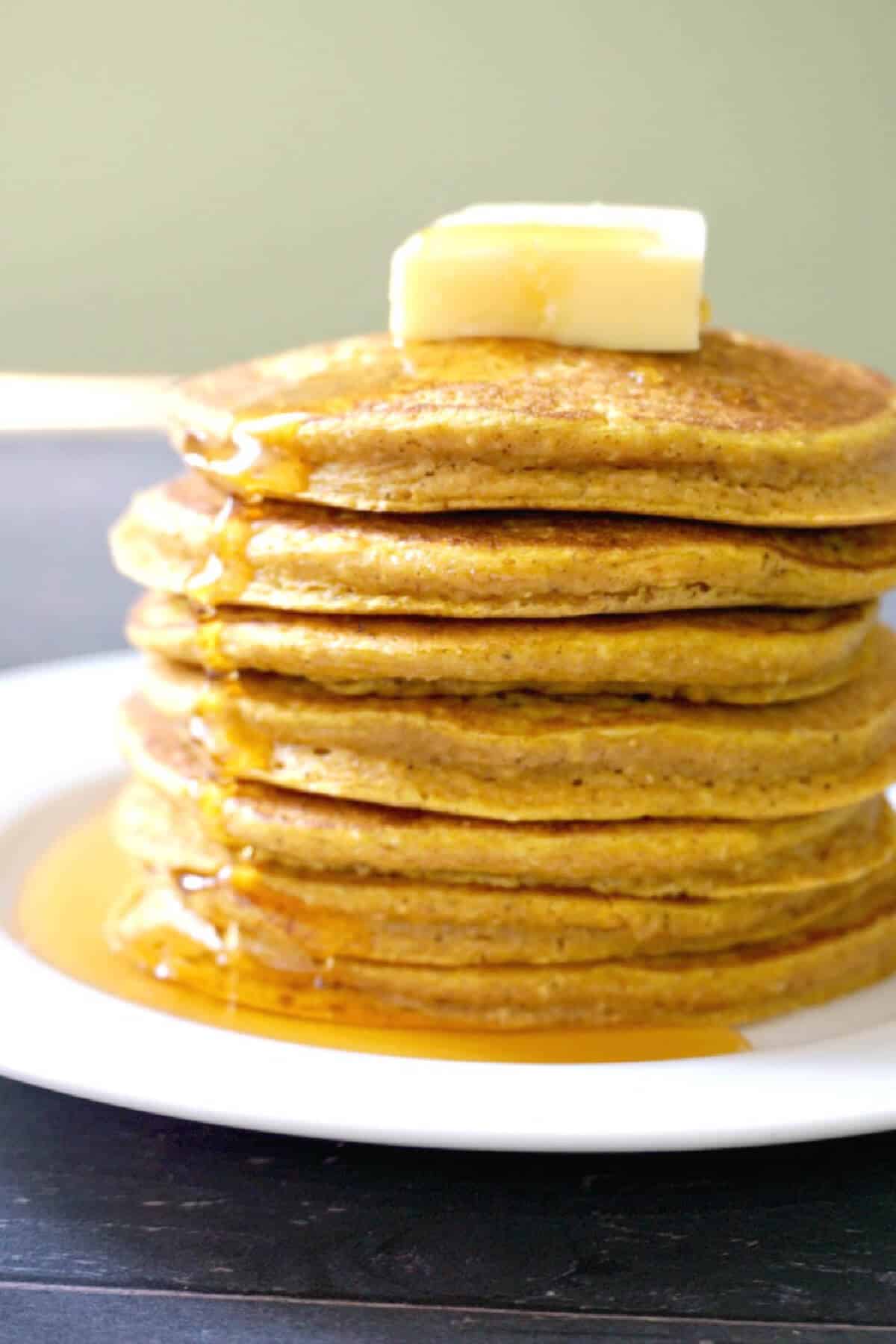 A stack of pancakes with a knob of butter at the top.