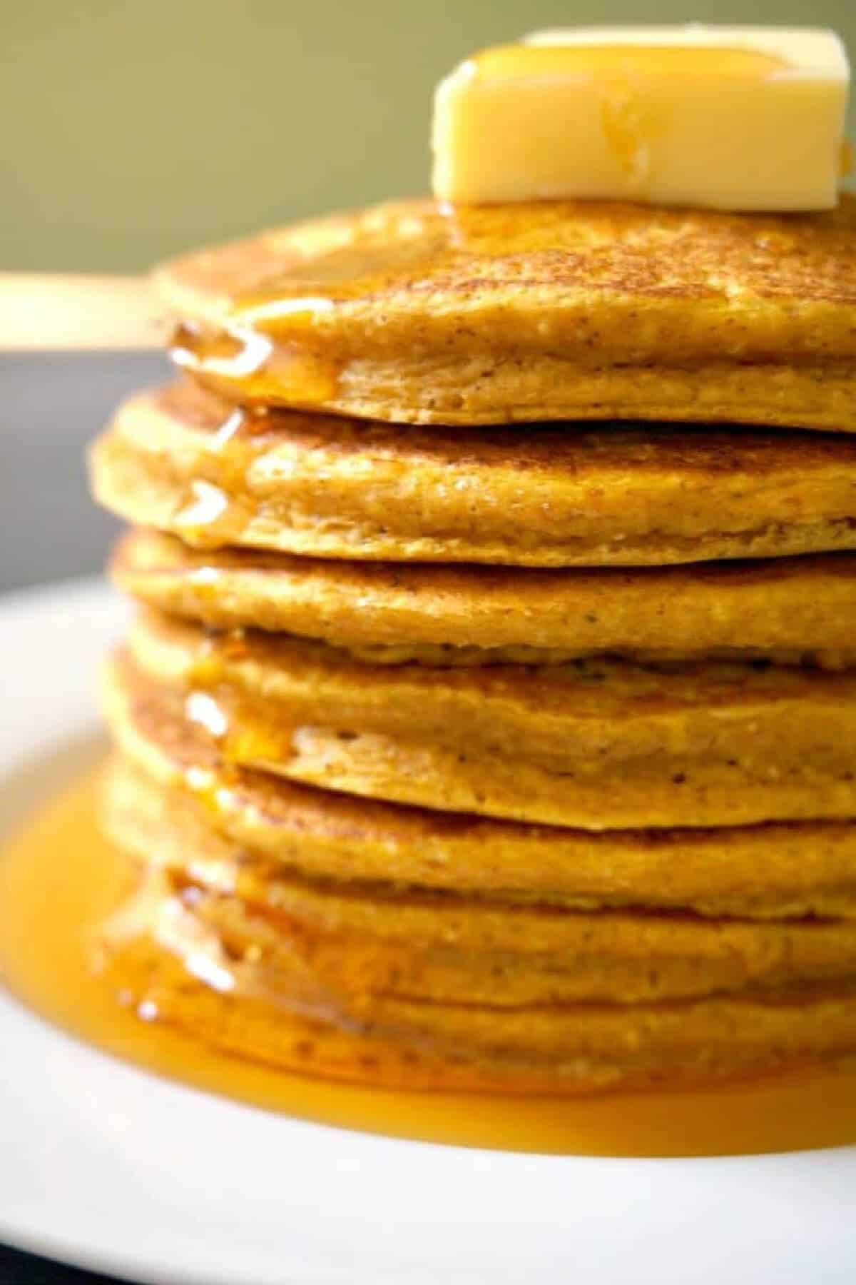 A stack of pumpkin pancakes with a knob of butter.