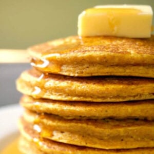 A stack of pumpkin pancakes topped with a knob of butter