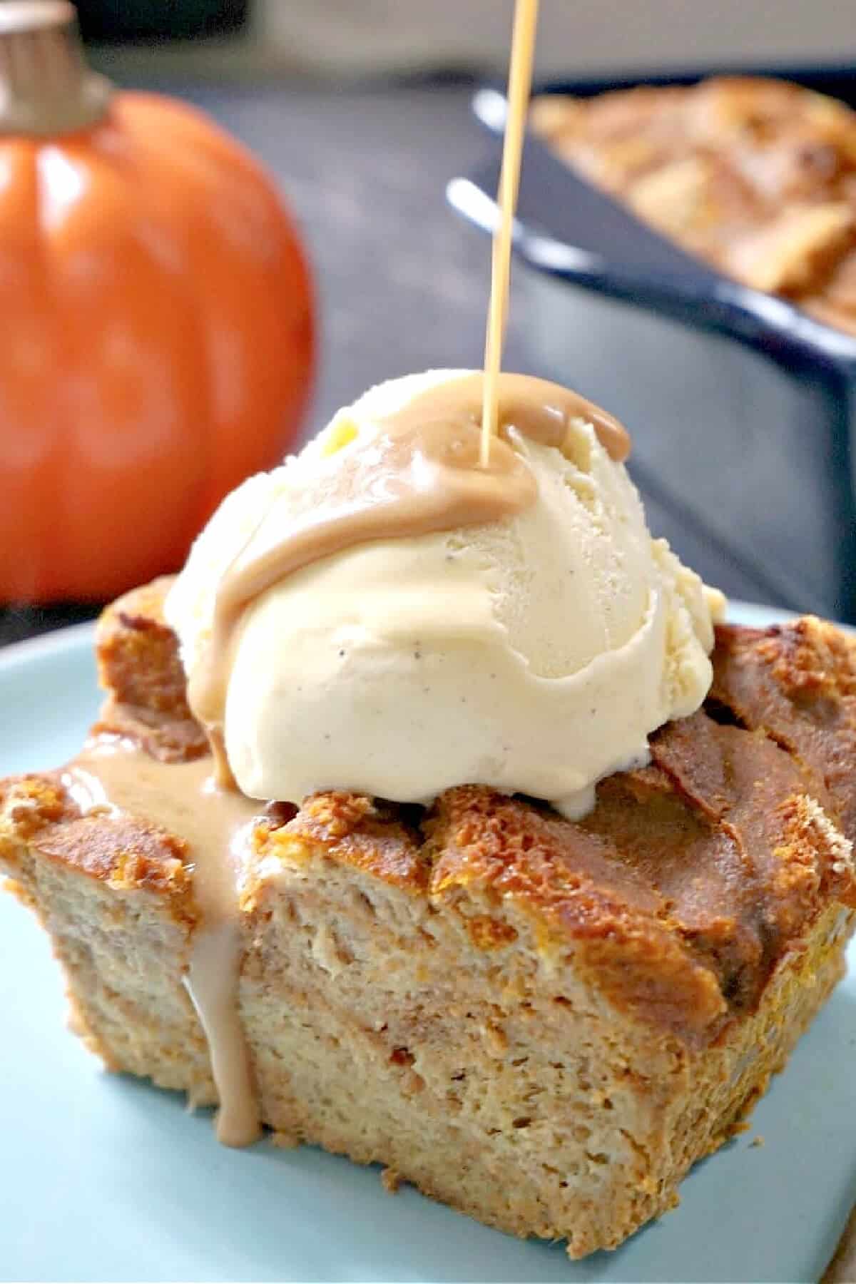 Butterscotch being poured over a slice of pumpkin bread pudding with vanilla ice cream.