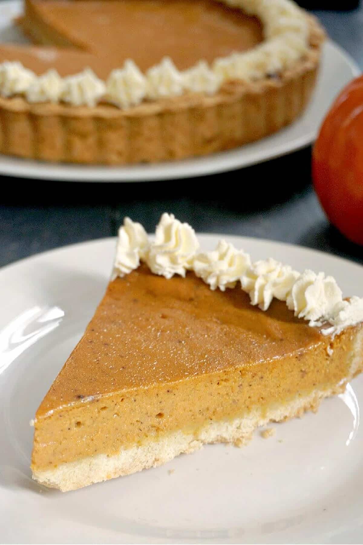 A slice of pumpkin pie on a white plate