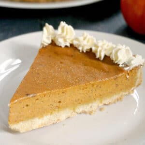 A slice of pumpkin pie on a white plate