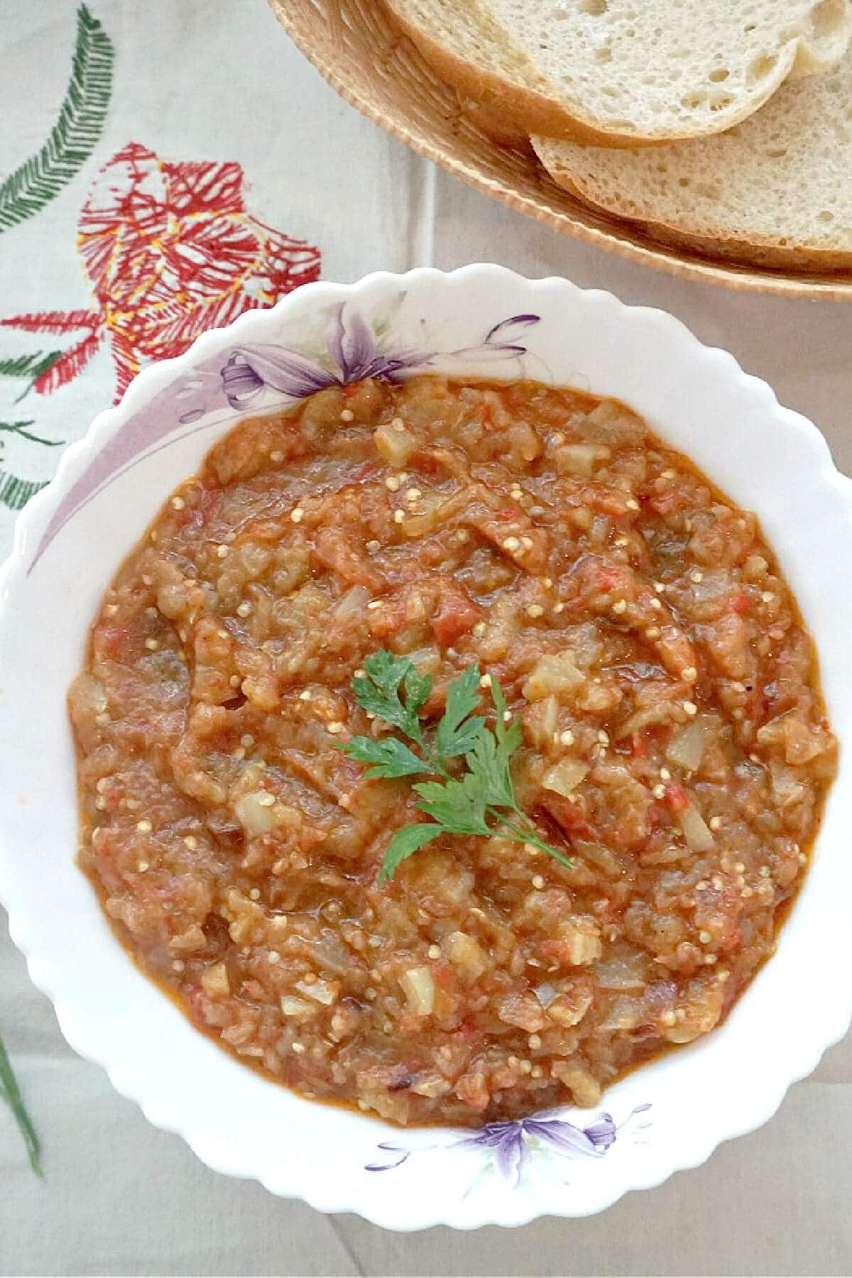 A white bowl with aubergine dip.