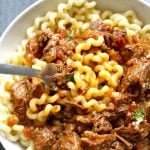 Slow Cooker Shredded Beef Ragu served with pasta, a complete dinner meal for your family. Jam-packed with rich Italian flavours, this dish is the best comfort food no matter the season. The beef is so tender it simply melts in your mouth, and the sauce is so flavourful. An easy dish that freezes well too, this dish is not only healthy, but the best recipe you can make in a crockpot. #crockpot, #slowcooker, #shreddedragu, #beefragu, #italianfood, #meatsauce, #healthyrecipes, #dinner, #kidsfood