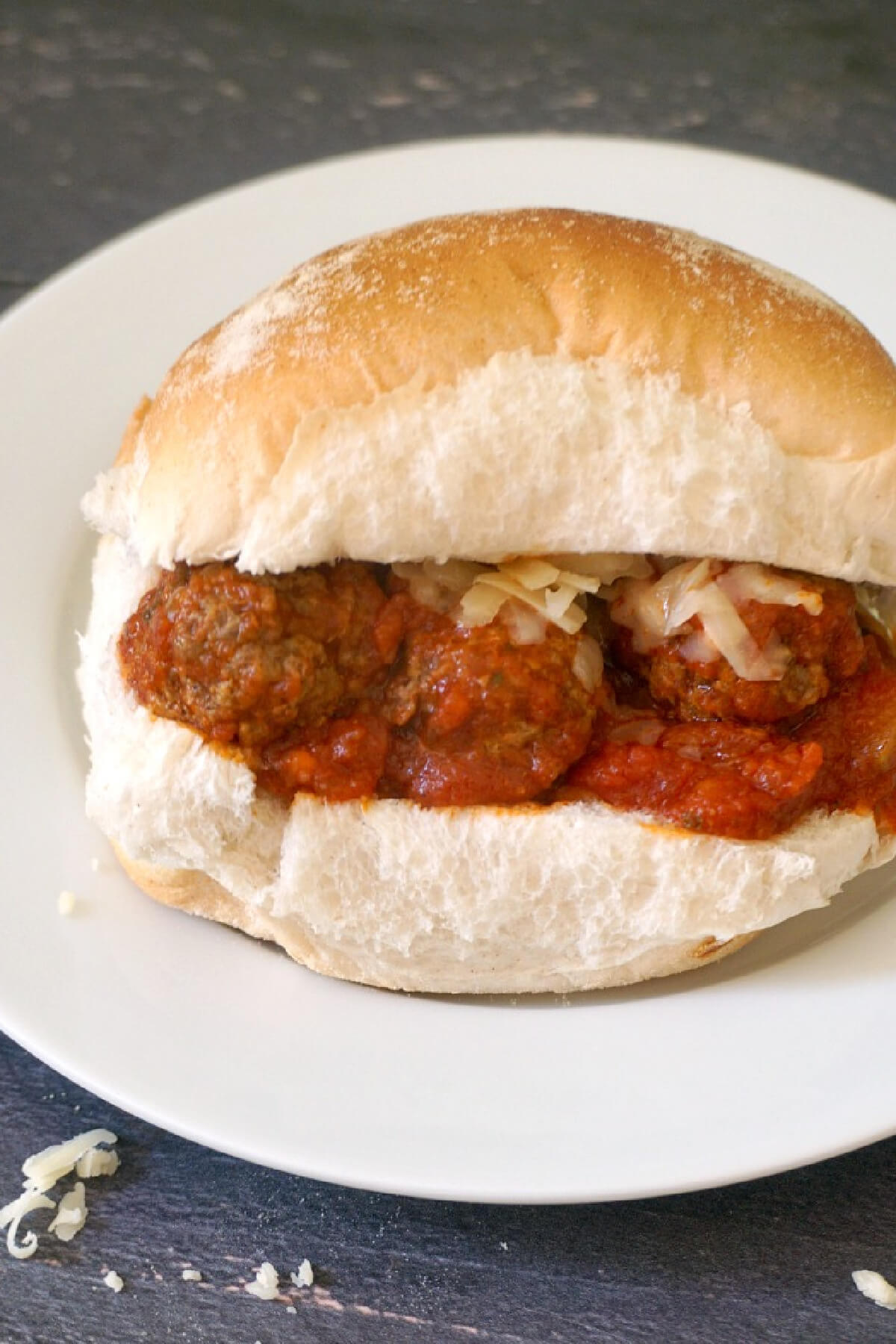 A white plate with a meatball slider.