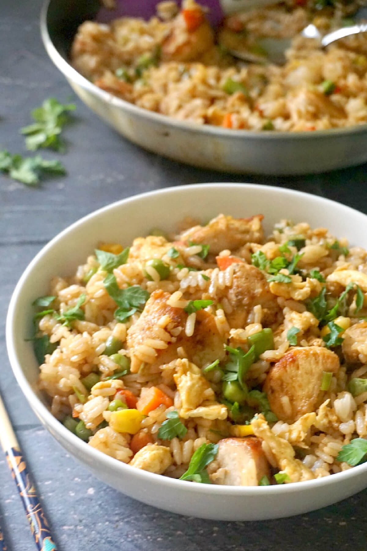 A white bowl with chicken egg fried rice.