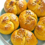 A light blue plate with 6 pumpkin dinner rolls