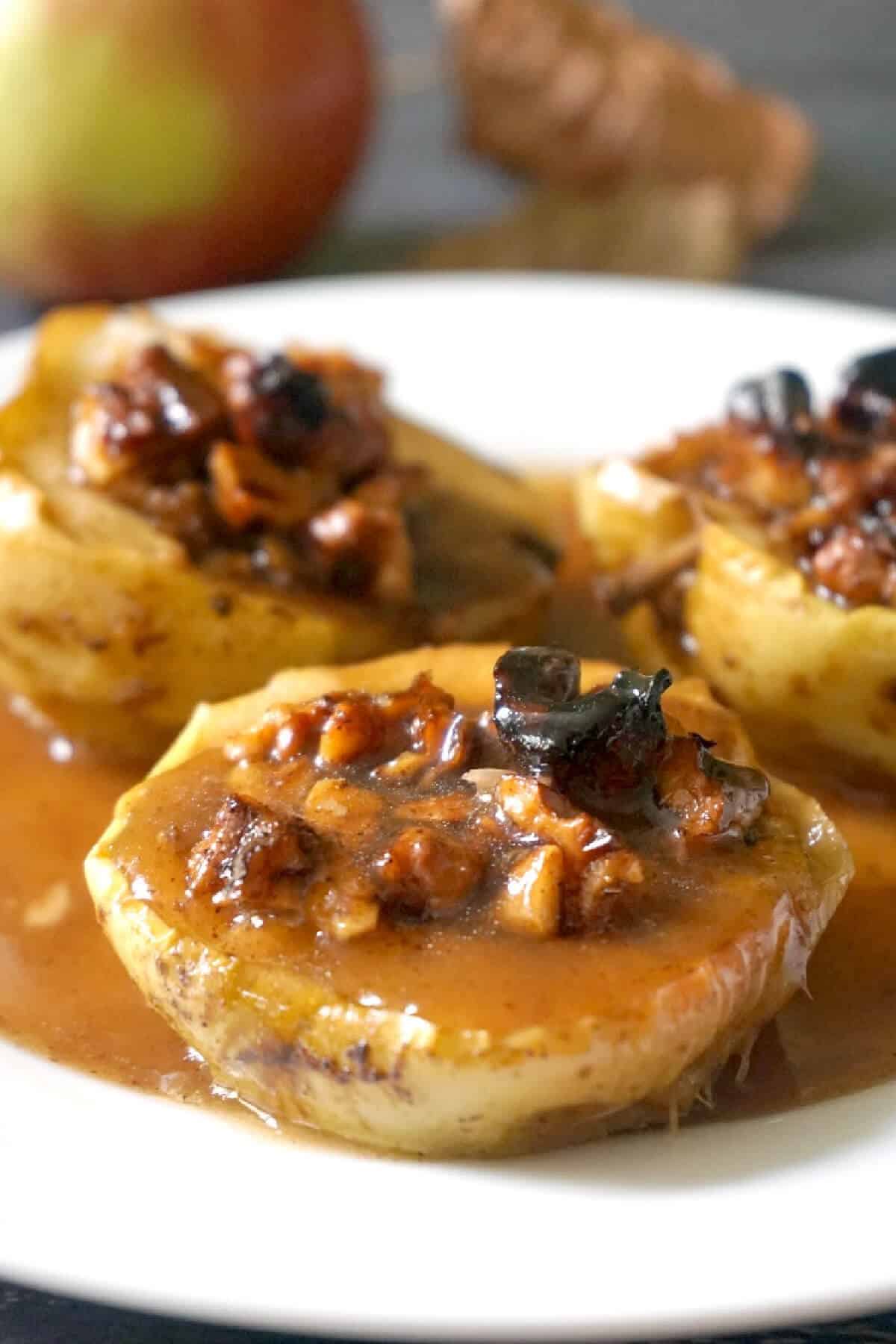 3 baked apple halves on a white plate.